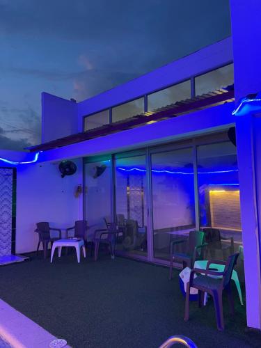 a room with chairs and tables and blue lights at Cabaña Ma Linda in Juan de Acosta