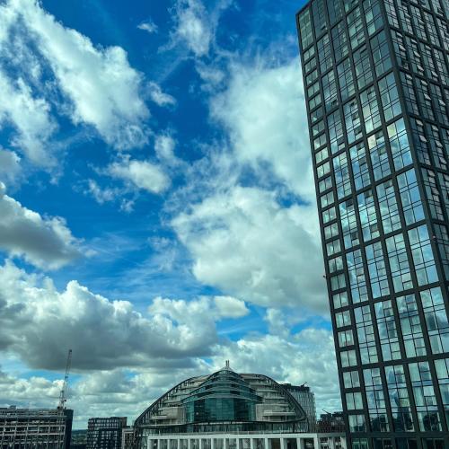 a tall building in a city with a cloudy sky at Crowne Plaza Manchester City Centre by IHG in Manchester