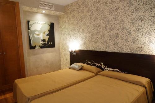 a bedroom with a bed and a wall with a picture at Don Agustin in San Luis de Sabinillas
