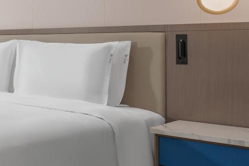a bedroom with a white bed and a tv at Holiday Inn Express Lanzhou Downtown by IHG in Lanzhou