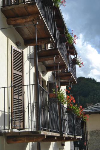 a building with potted plants on the balconies at B&B Locanda Del Mulino in Pamparato