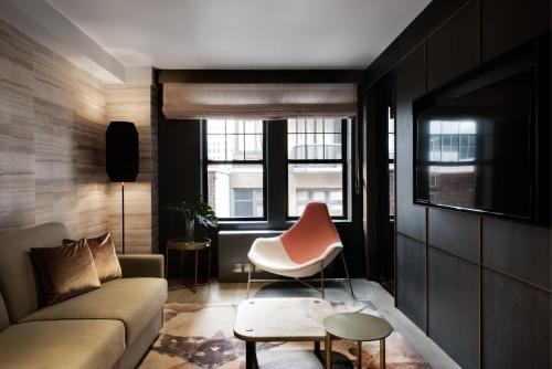 a living room with a couch and a chair at The Time New York, part of JdV by Hyatt in New York