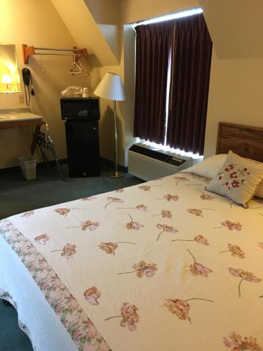 a bedroom with a bed with a floral bedspread at Buffalo Lodge in Chugwater