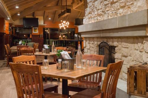 a restaurant with a wooden table and chairs and a fireplace at Toftrees Golf Resort in State College