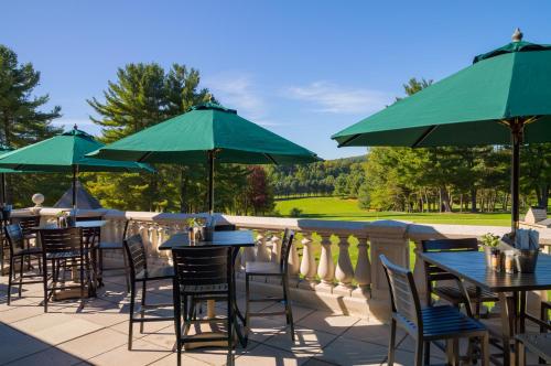 a patio with tables and chairs with green umbrellas at Toftrees Golf Resort in State College