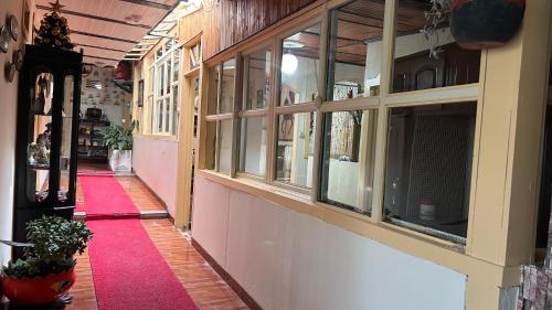 a hallway of a store with windows and a red carpet at Posada Martha Tolima in Salento