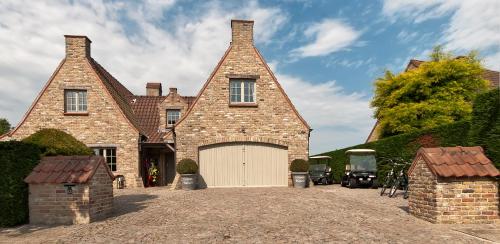 a large brick house with a large garage at B&B Colombe Blanche in Knokke-Heist