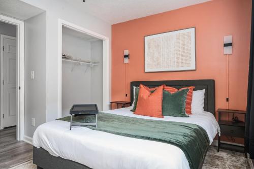アトランタにあるThe Traveler's Retreat, 5 mins to airport and 15 mins to downtownのベッドルーム1室(オレンジ色の壁のベッド1台付)
