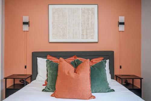 a bedroom with a bed with orange walls and pillows at The Traveler's Retreat, 5 mins to airport and 15 mins to downtown in Atlanta