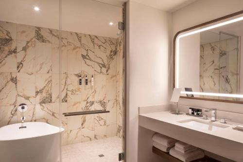 a bathroom with a sink and a shower at Caesars Republic Scottsdale, a Hilton Hotel in Scottsdale