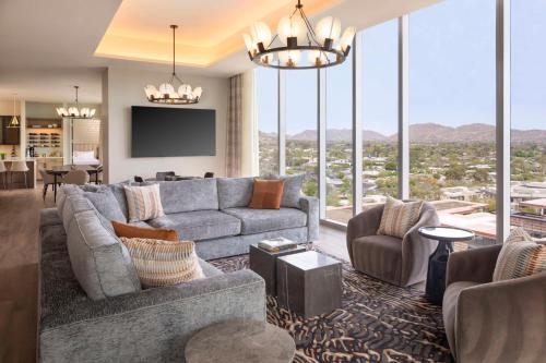 a living room with a couch and a tv at Caesars Republic Scottsdale, a Hilton Hotel in Scottsdale