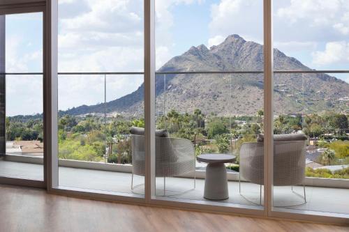 a room with a large window with a table and chairs at Caesars Republic Scottsdale, a Hilton Hotel in Scottsdale