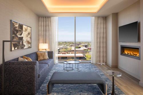 a living room with a couch and a fireplace at Caesars Republic Scottsdale, a Hilton Hotel in Scottsdale