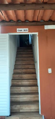 a staircase leading up to a building with a sign at Chalé Pé na Areia e Piscina Privativa em Barra do Jacuípe in Camaçari
