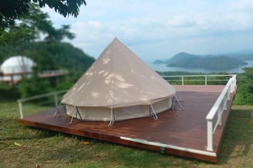 a white tent on a wooden deck with a view at The Hilltop Erawan in Si Sawat