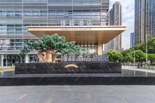 a statue of a tree in front of a building at 佛山南海金融城瑾程酒店 in Nanhai
