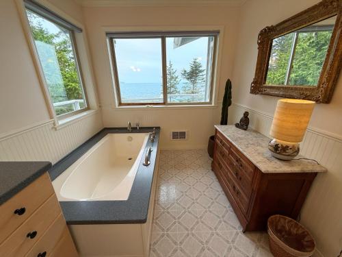 a bathroom with a large tub and a window at EcoBluff Retreat - Sunset & Water Views! in Port Townsend
