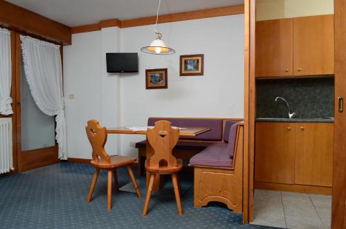 a dining room with a table and two chairs at Ski Residence in San Martino di Castrozza