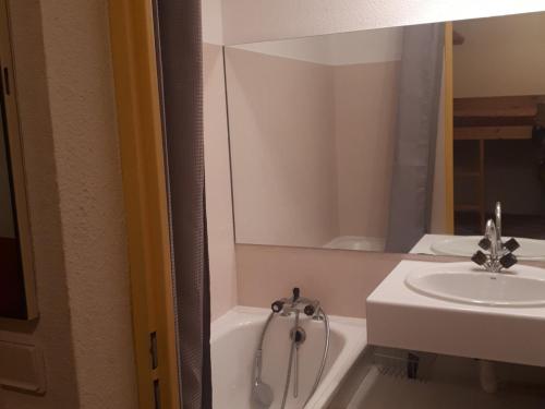 La salle de bains est pourvue d'un lavabo et d'une baignoire blanche. dans l'établissement Studio/T1 26m² 5 pers avec balcon et équipement complet à Saint-François-Longchamp - FR-1-807-12, à Saint-François-Longchamp