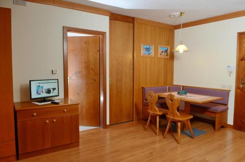 a kitchen with a table and chairs and a television at Ski Residence in San Martino di Castrozza