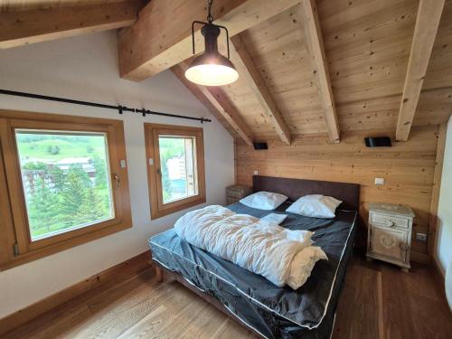 une chambre avec un lit dans une pièce aux murs en bois dans l'établissement Duplex lumineux 8 pers, proche pistes, animaux ok - FR-1-811-29, à Les Deux Alpes