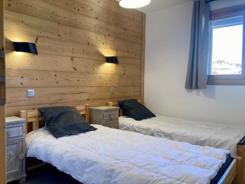 deux lits dans une chambre aux murs en bois dans l'établissement Appartement lumineux, 250m des pistes, 6 pers, animaux admis - FR-1-811-3, à Les Deux Alpes