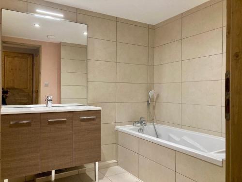 une salle de bain avec un lavabo, une baignoire et un miroir dans l'établissement Spacieux duplex lumineux à 250m des pistes, animaux admis - FR-1-811-5, à Les Deux Alpes