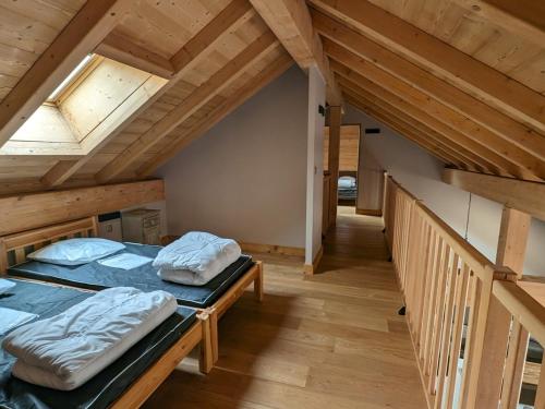 deux lits dans une chambre avec plafonds en bois dans l'établissement Spacieux duplex lumineux à 250m des pistes, animaux admis - FR-1-811-5, à Les Deux Alpes