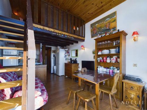 - une cuisine et une salle à manger avec une table et des lits superposés dans l'établissement Studio avec mezzanine pour 4 pers, proche commerces et remontées - FR-1-398-677, à Montvalezan