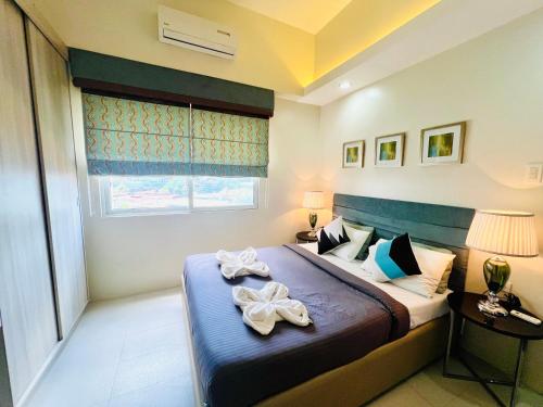 a bedroom with a bed with two towels on it at City Center 1-bedroom with balcony and washer in Cebu City