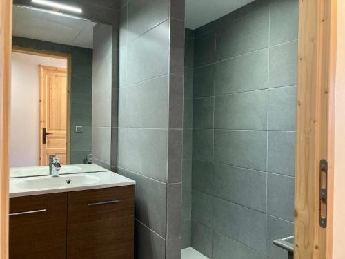 une salle de bain avec un lavabo et un miroir dans l'établissement Appartement neuf, lumineux, à 250m des pistes, animaux admis - FR-1-811-4, à Les Deux Alpes