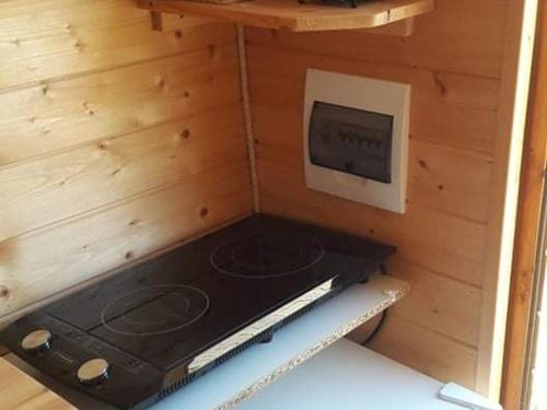 Ce chalet en bois comprend une cuisinière et une télévision. dans l'établissement Cabane avec jacuzzi privatif et accès à ferme pédagogique - FR-1-410-459, à Cérans-Foulletourte