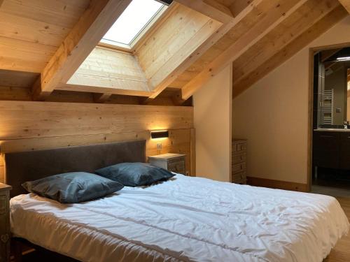 une chambre avec un grand lit avec une lucarne dans l'établissement Grand appart lumineux 7 pièces, 250m pistes, 10 pers, animaux admis - FR-1-811-13, à Les Deux Alpes