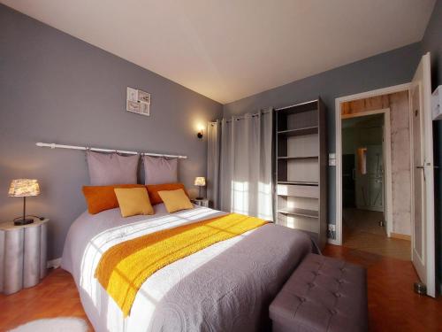 a bedroom with a large bed with yellow and orange pillows at Évasion champêtre à Janville: charme et confort pour 6 personnes - FR-1-581-145 in Le Puiset