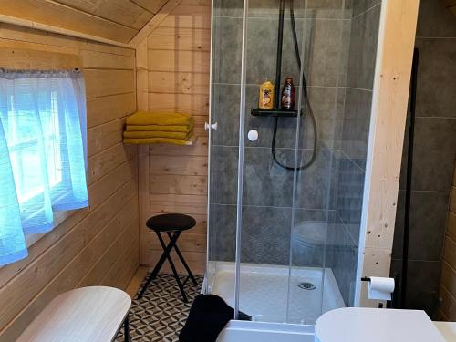 a bathroom with a shower in a wooden cabin at Kota finlandais avec bain nordique privatif et ferme pédagogique - FR-1-410-457 in Cérans-Foulletourte