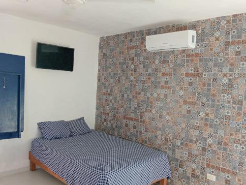 a bedroom with a bed and a wall at Happy Sunsets Yucalpetén in Progreso