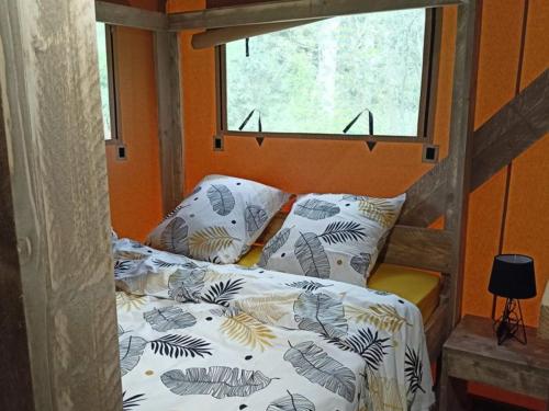 - une chambre avec un lit, une fenêtre et un lit avec des oreillers dans l'établissement Cabane Trappeur Lodge avec Jacuzzi et Ferme Pédagogique - FR-1-410-458, à Cérans-Foulletourte