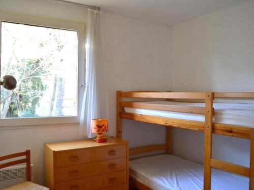 une chambre avec deux lits superposés et une fenêtre dans l'établissement Appartement 2 pièces avec loggia à 150m de la plage, animaux acceptés, garage compris - FR-1-776-111, à Argelès-sur-Mer