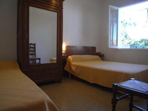 une chambre avec deux lits, un miroir et une fenêtre dans l'établissement Appt 3P pour 6 proche plage avec jardin privé, animaux admis - FR-1-776-109, à Argelès-sur-Mer