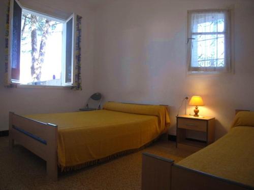 deux lits dans une chambre avec deux fenêtres dans l'établissement Appartement 2 pièces près de la plage, jardin privé, animaux admis - FR-1-776-110, à Argelès-sur-Mer