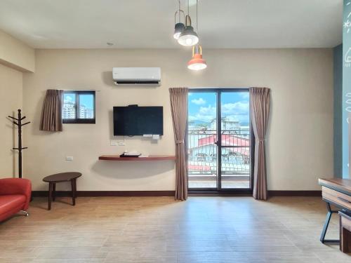 a living room with a red couch and a tv at Green Castle in Ch'ieh-tung-chiao