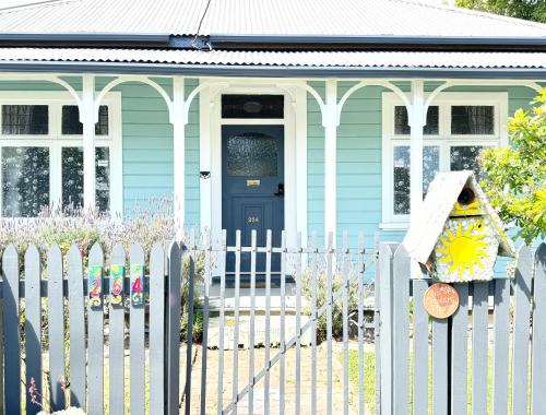 a blue house with a white picket fence at 298 Home in Christchurch