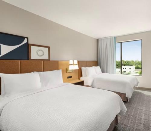 a hotel room with two beds and a window at Staybridge Suites Milwaukee West-Oconomowoc by IHG in Oconomowoc