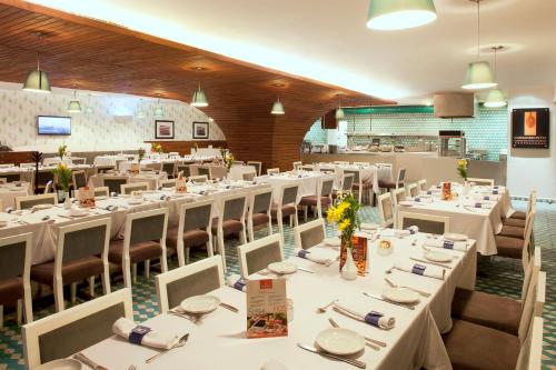 a large dining room with white tables and chairs at Emporio Mazatlan in Mazatlán