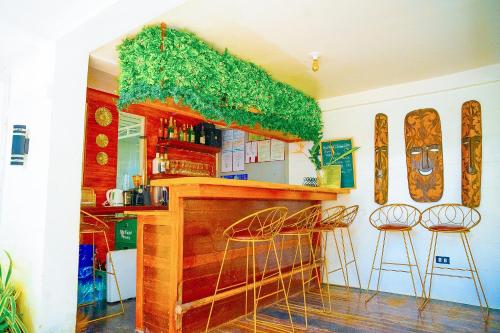 a bar with two stools and a counter withgrass at Ciudad Caliente by The Lavana in Talisay