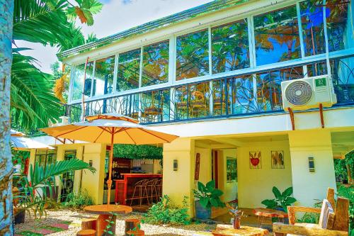a house with an umbrella and tables and chairs at Ciudad Caliente by The Lavana in Talisay