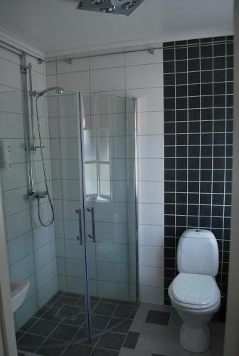 a bathroom with a toilet and a glass shower at Hotell Östermalm in Motala