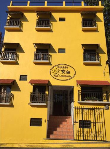 a yellow building with a sign on the side of it at Posada Kin in Palenque