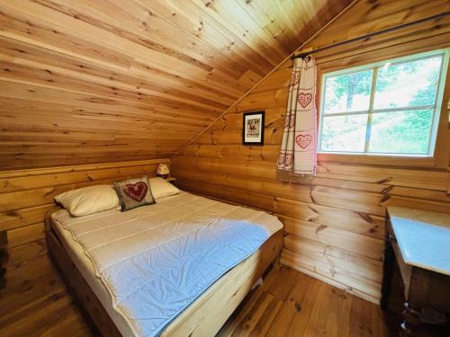 une chambre avec un lit dans une cabane en rondins dans l'établissement Chalet 4 chambres proche pistes – Confort et charme - FR-1-353-151, à La Plagne Tarentaise