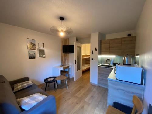 un petit salon avec un canapé et une cuisine dans l'établissement Studio rénové 4 pers. avec terrasse et parking, Crest-Voland - FR-1-733-159, à Crest-Voland